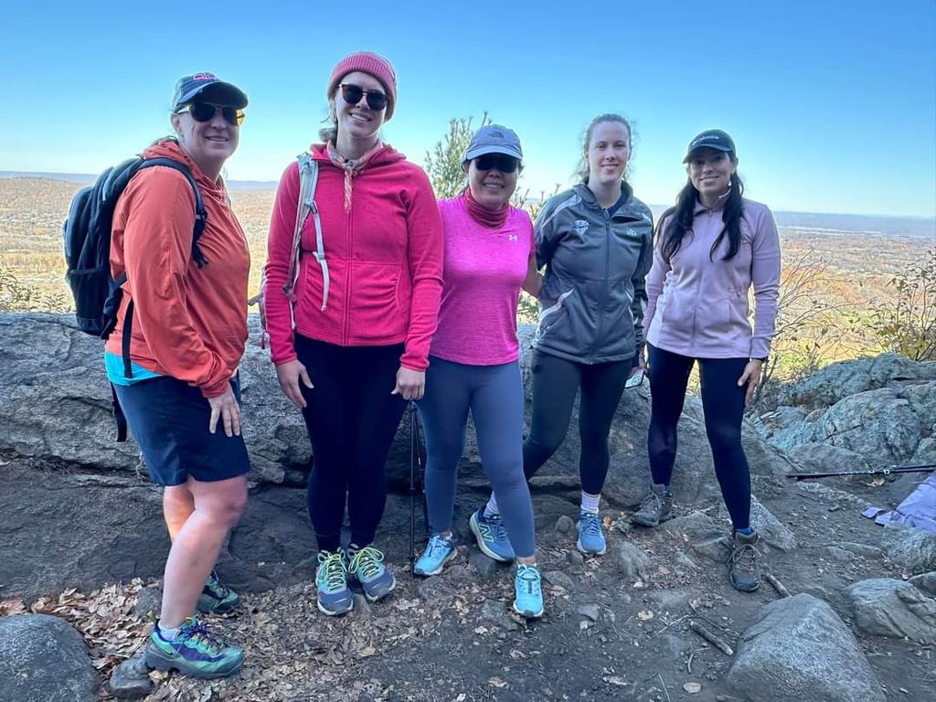 A group of hikers posing together at a rocky viewpoint.