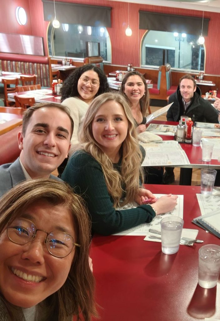 KC and a group of companions enjoying a meal together at a diner.